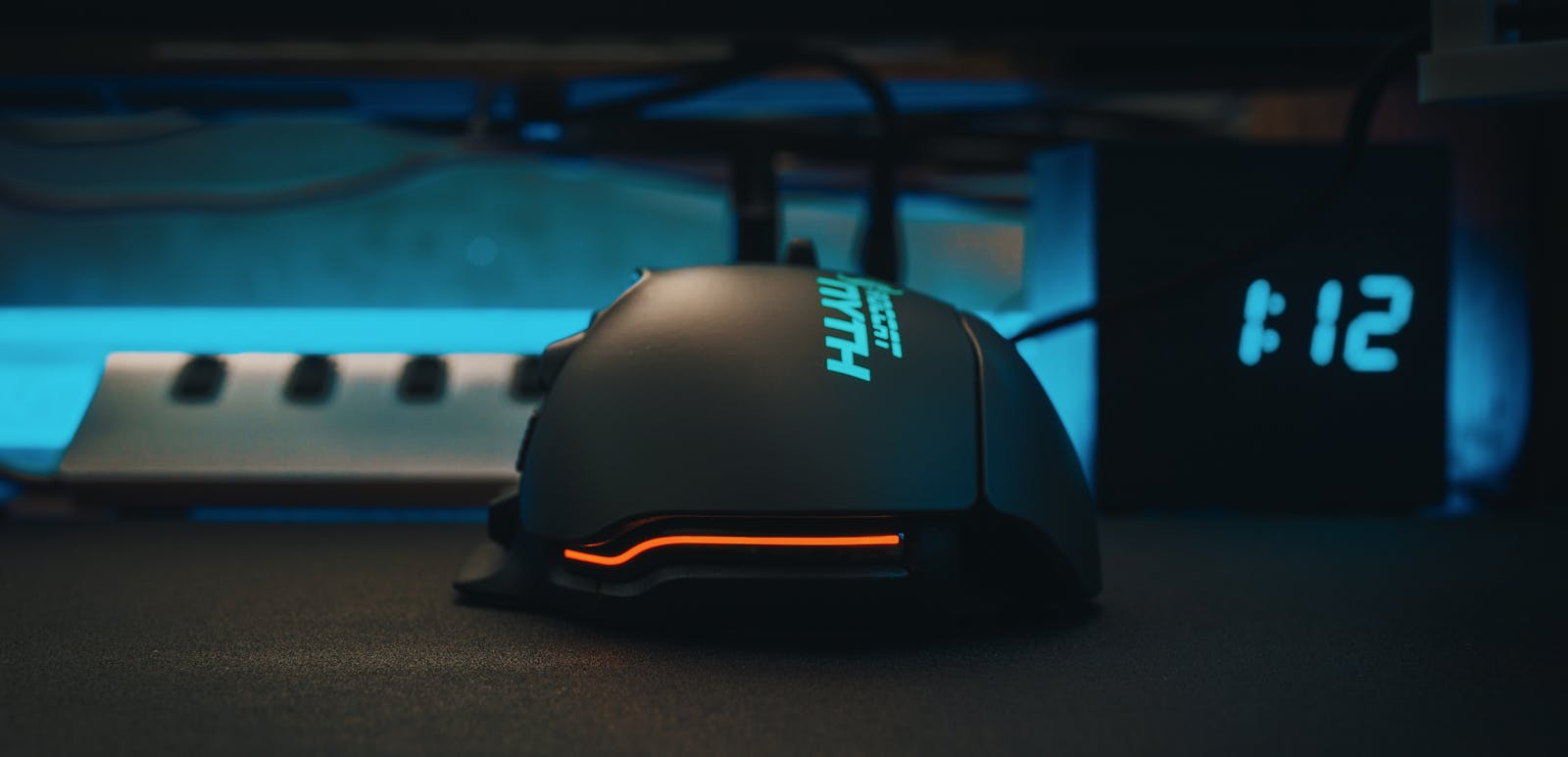 Close-up of a futuristic gaming mouse next to a digital clock, showcasing modern technology.
